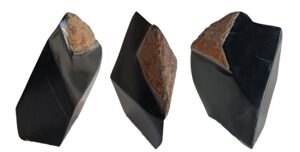 Figure 11. « Austral noir ». Cowell Nephrite, Australie. Trois faces de la néphrite noire et gangue limoniteuse partiellement conservée. J.P. Milesi, 2025.